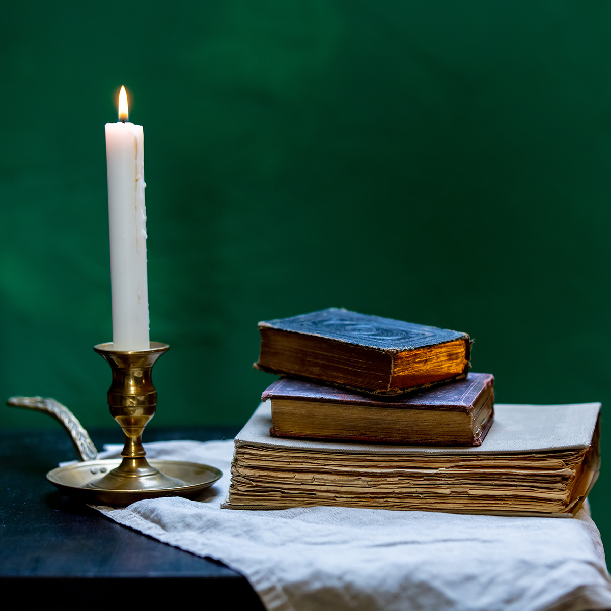 Old books and a lit candle