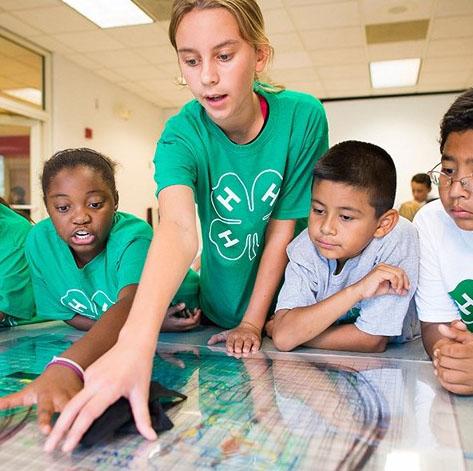 Kids in 4-H are instructed on a project