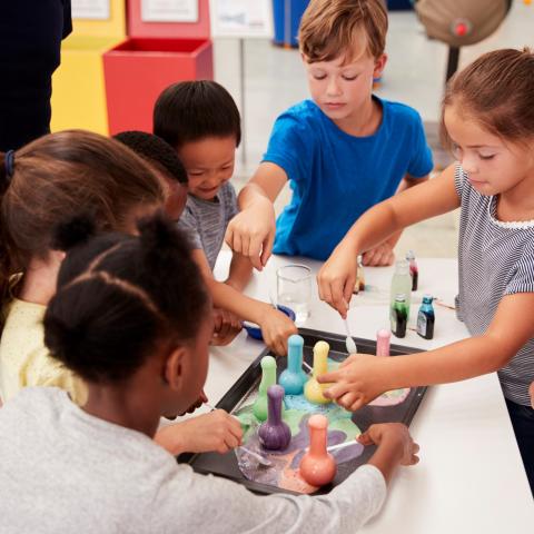 Kids grouped around a table of science experiments