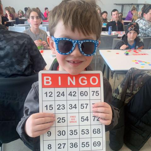 Child holding BINGO card