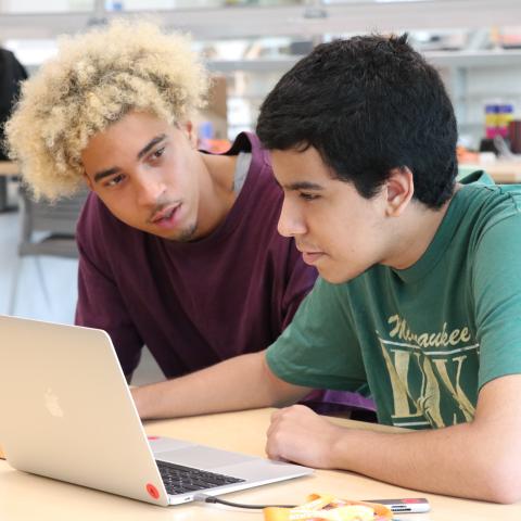 Two teens in front of computer