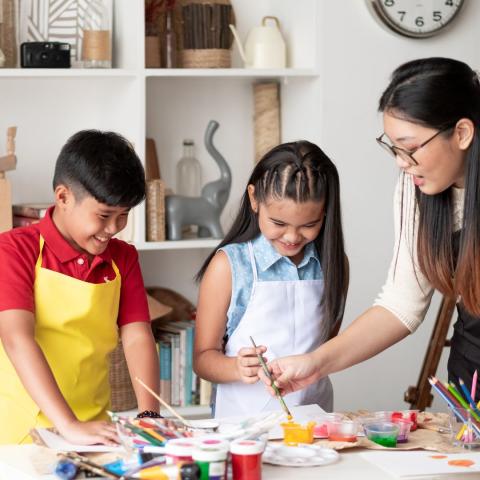 Parent and two children painting