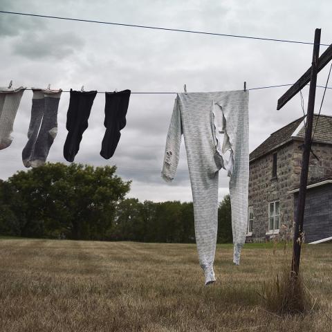 laundry hanging on a line outside an old farm house