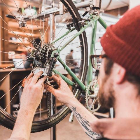 Bike mechanic working on a rear bicycle wheel