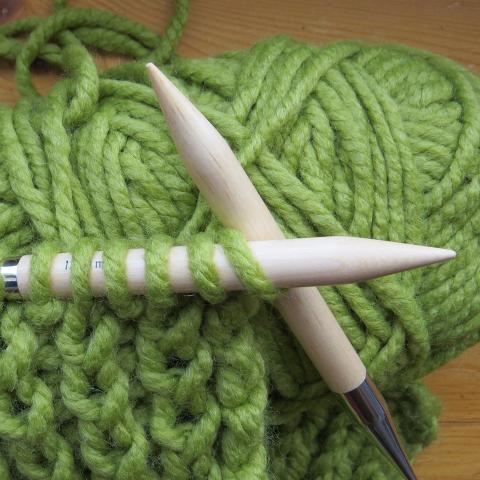 Knitting needles with green yarn