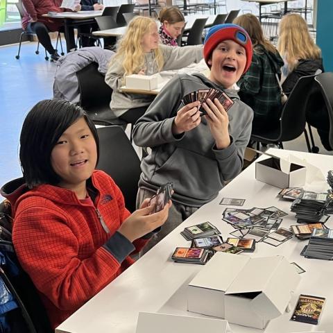 Two teen boys playing with Magic cards.