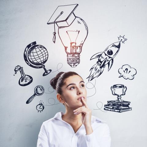 Woman standing in front of a white wall with a thoughtful look on her face. Hand-drawn pictures of a globe, a lightbulb with a graduates cap and several other icons on on the wall behind her.