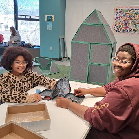 Child and adult, smiling, playing Battleship