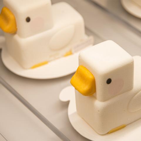 A photograph of cake in the shape of ducks.
