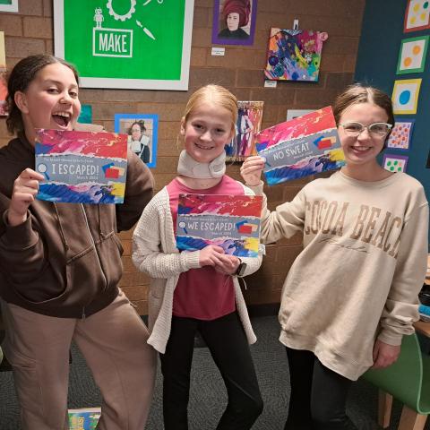 A photograph of children holding certificates of completion for an escape room. 