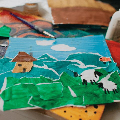 A picture of a farm made by torn colored paper.