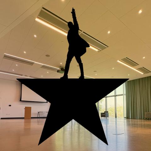 A photograph of the event space featuring the logo for the Hamilton movie.