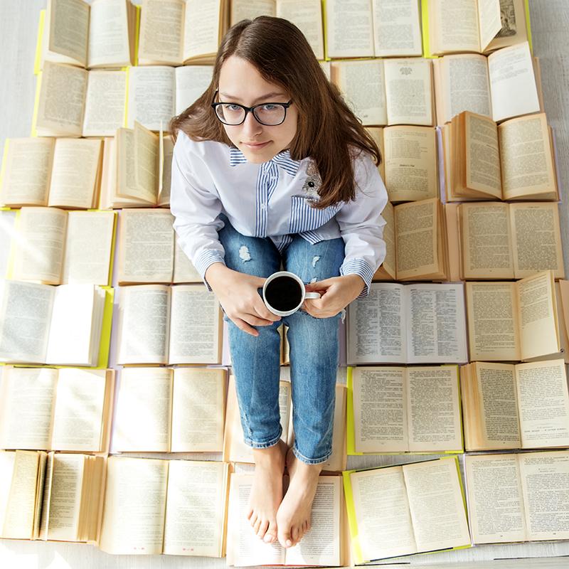 teen sitting on open books