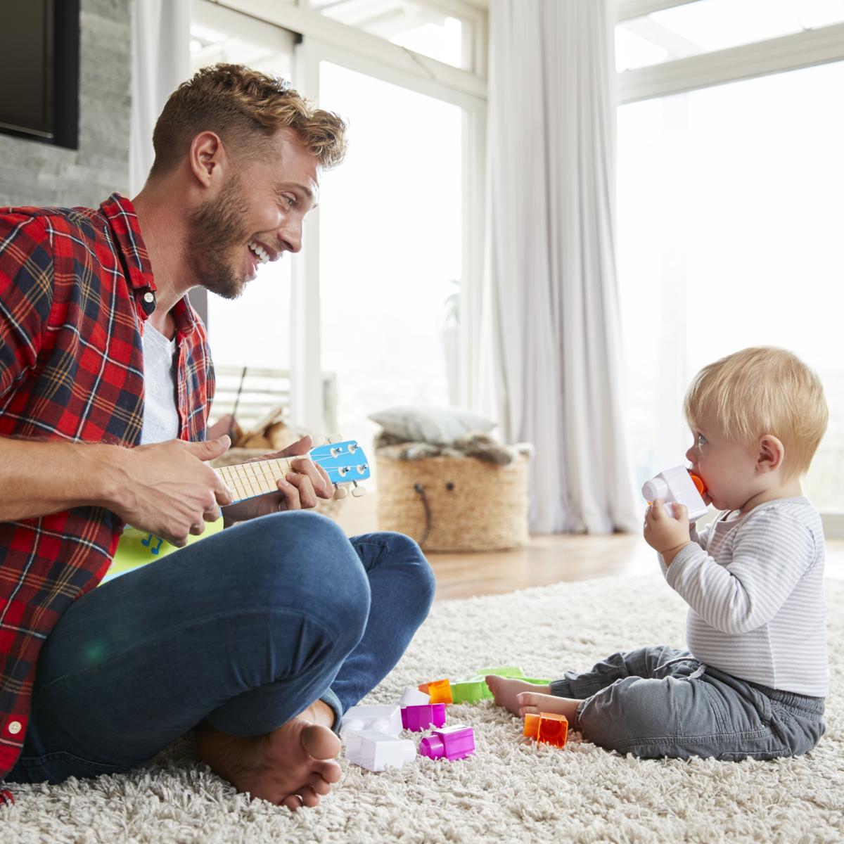 Man playing ukulele for child