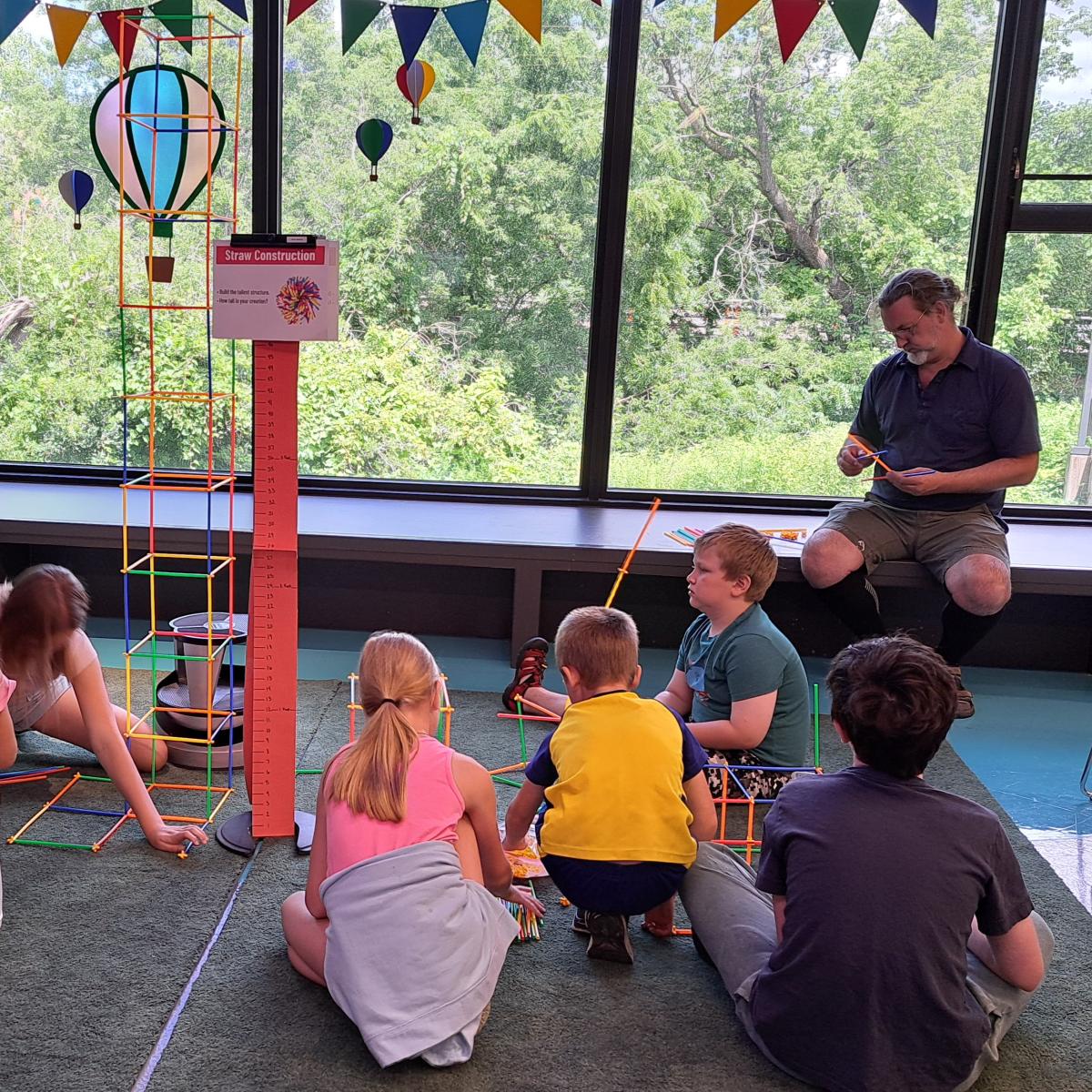 Group of children building a tower out of straws.