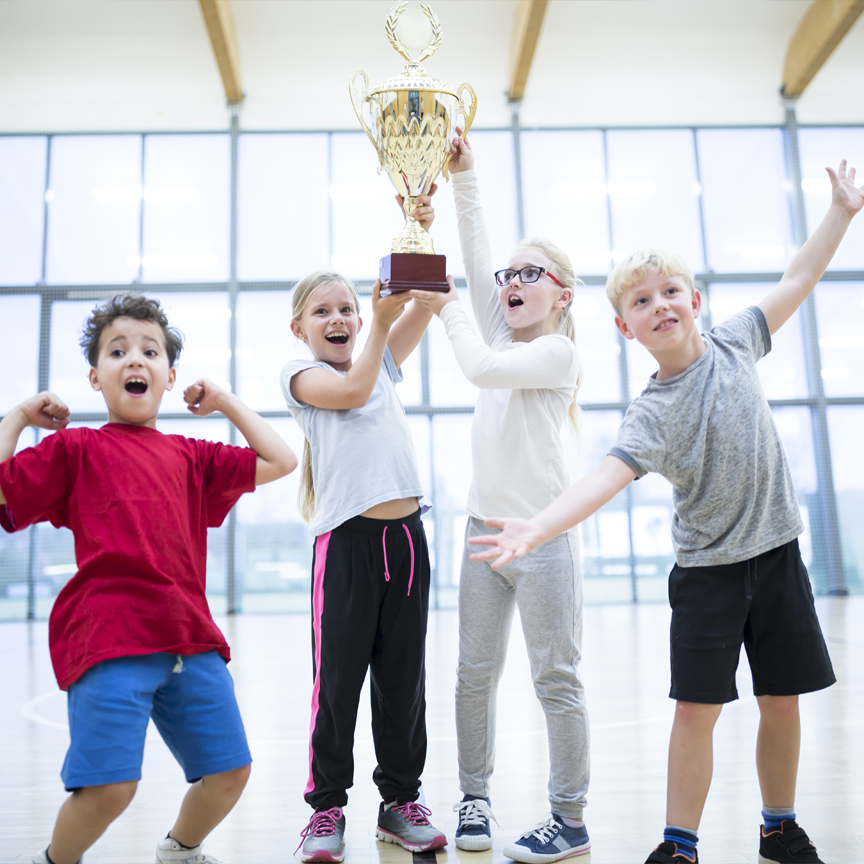 A photograph of children posing with a trophy.