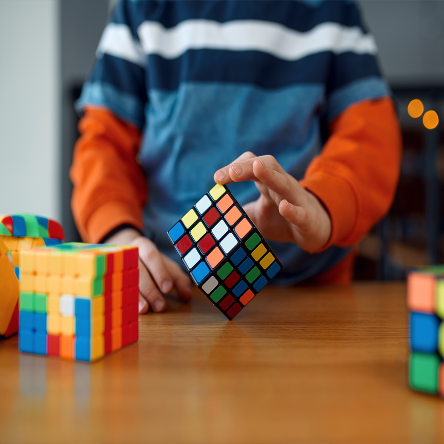 A photograph of a child posing with puzzles.