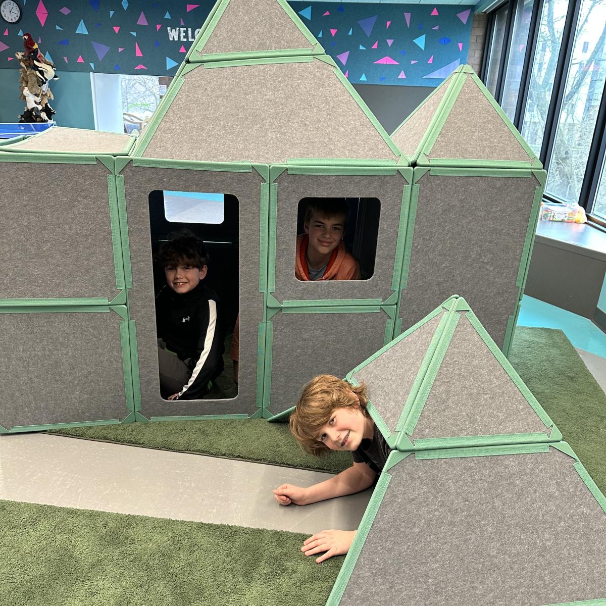 Three boys playing in building set.