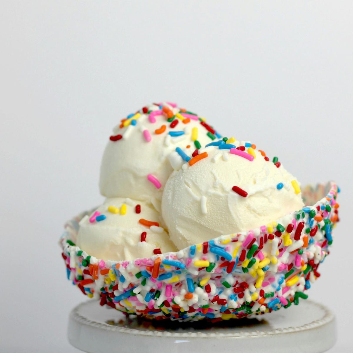 Sprinkle bowl with scoops of vanilla ice cream.