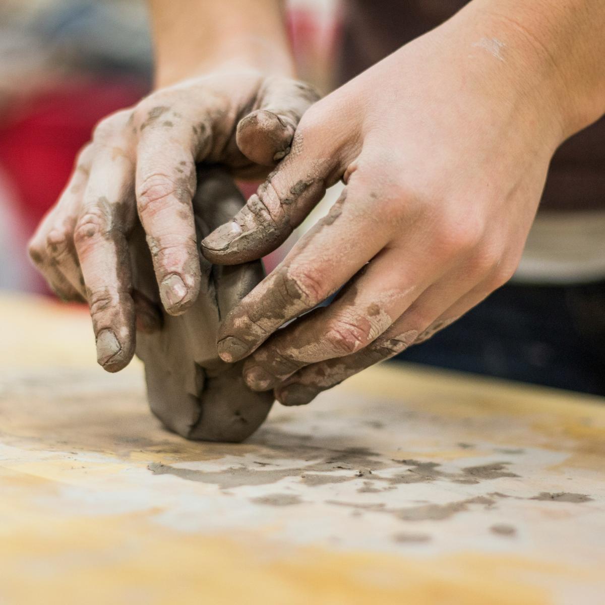 Hands working with clay.