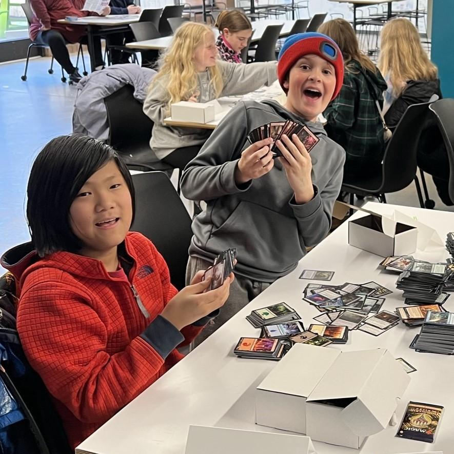 Two teen boys playing with Magic cards.