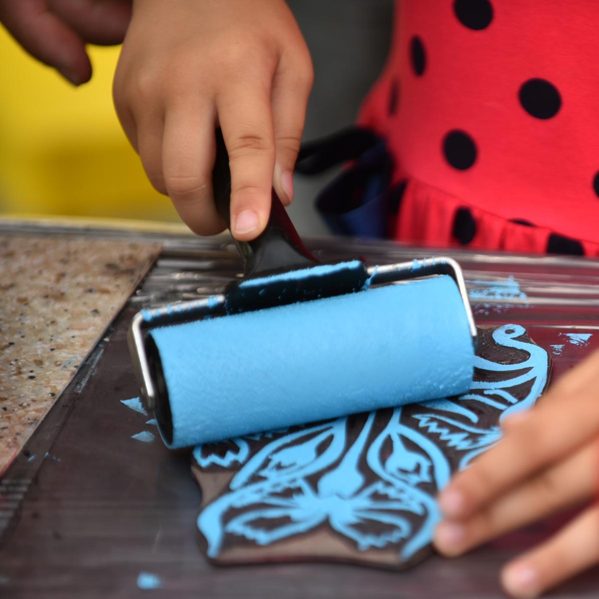 Child using a roller on a raised pattern