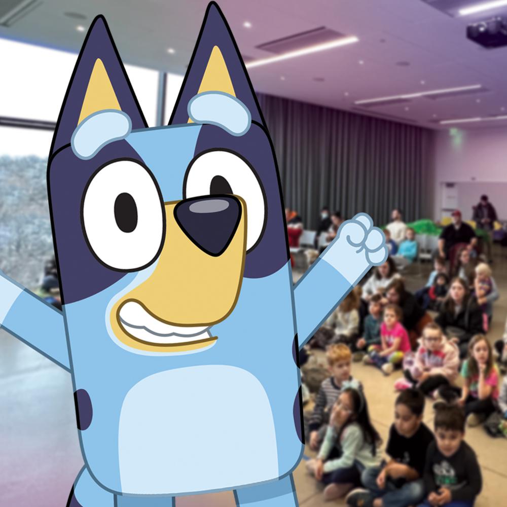 An image of the cartoon dog Bluey standing in the library event space.