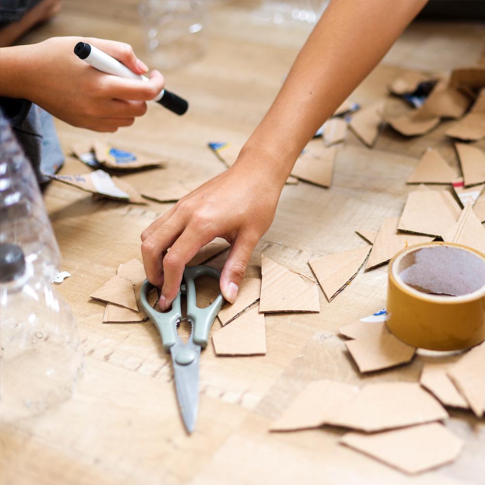 A photograph of children crafting with cardboard.